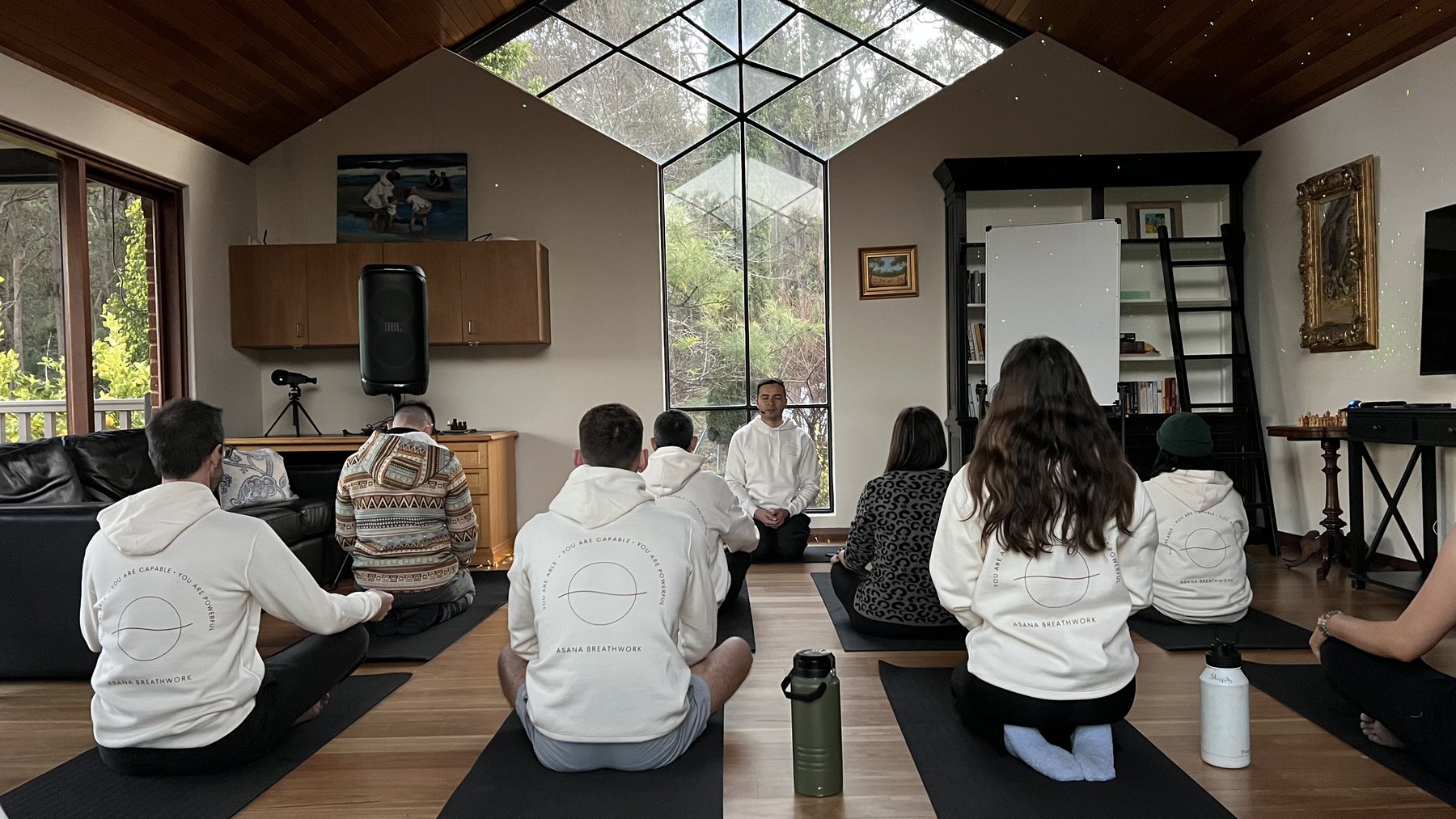 Facilitator guiding a seated meditation beneath the retreat skylight