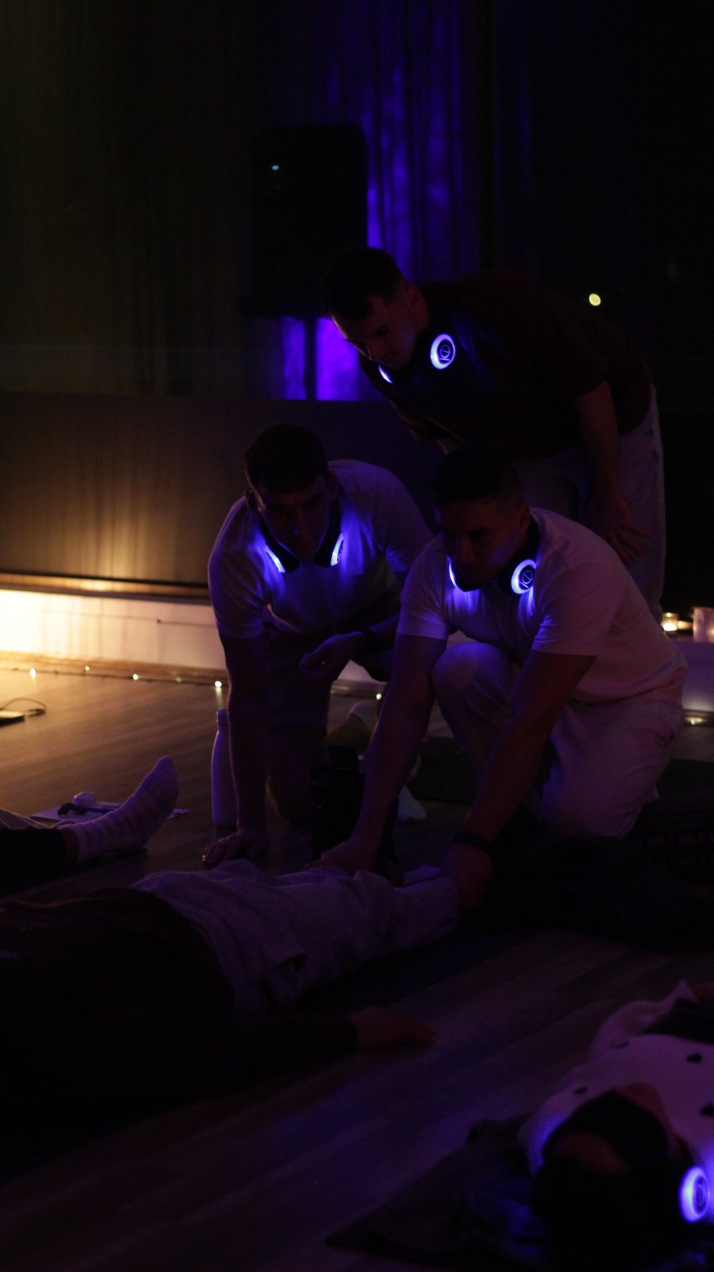 Trainees offering hands-on support during a candlelit night session